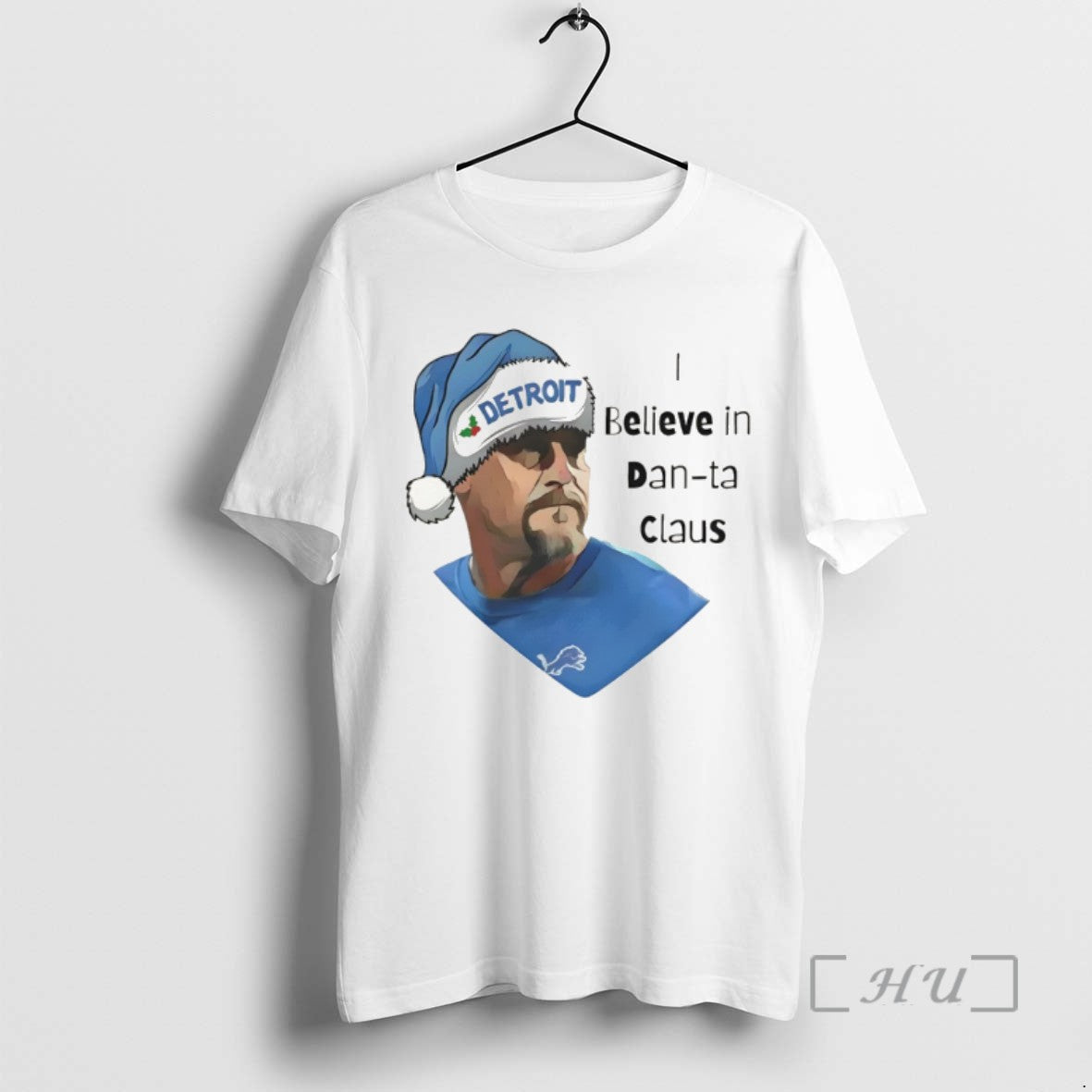 Trending I Believe In Dan Ta Claus Dan Campbell Detroit Lions Football Christmas 2025 Tee